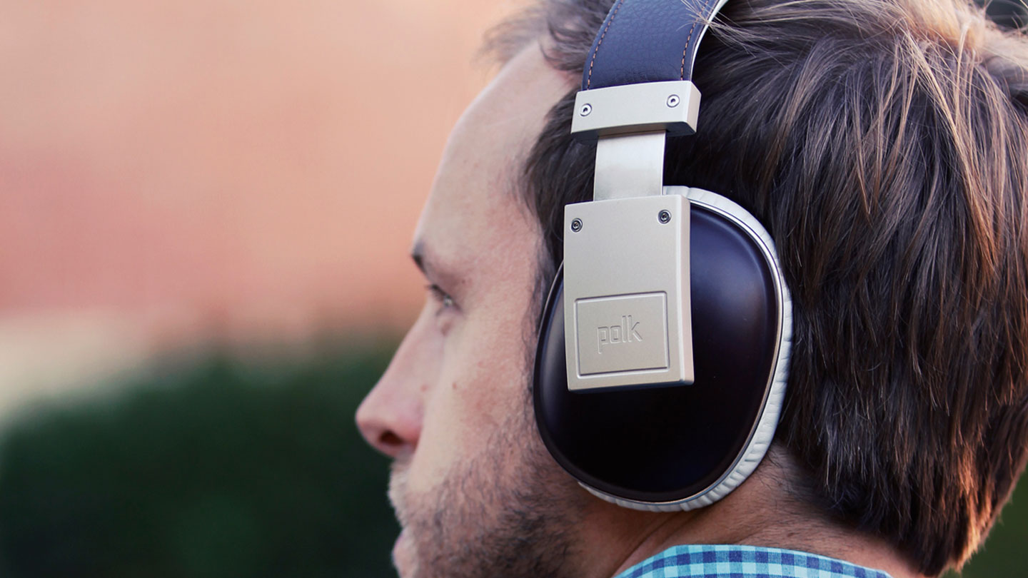 A man listening on Polk Audio headphones, heritage brand design with state-of-the-art technology